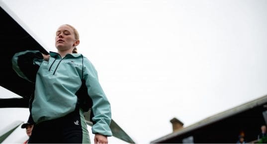 CUBC female athlete carrying boat