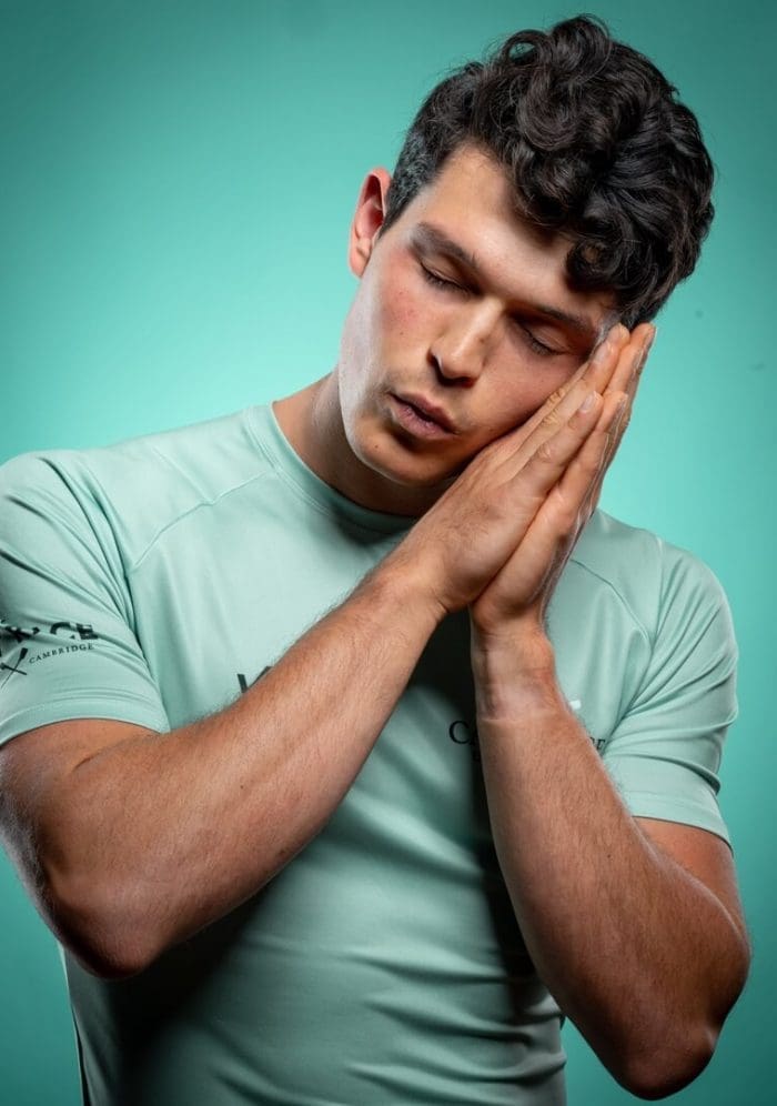 CUBC athlete in light blue top pretending to sleep
